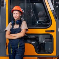Smiling,Female,Labor,Worker,Near,Forklift,Driver,In,Industry,Factory